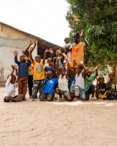 Motorcycle rider with children in African village